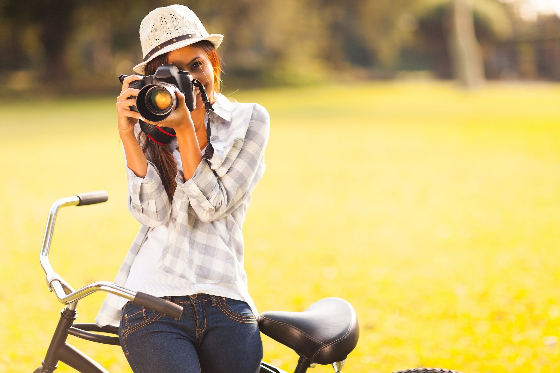 girl brown hair hat a camera bike smile green