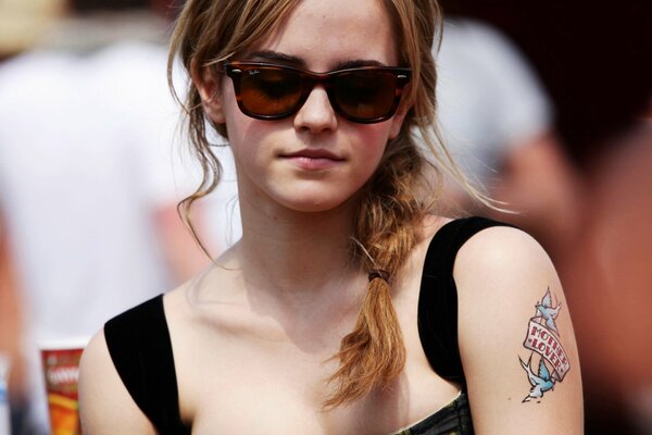 Jolie Emma Watson dans des lunettes avec un tatouage