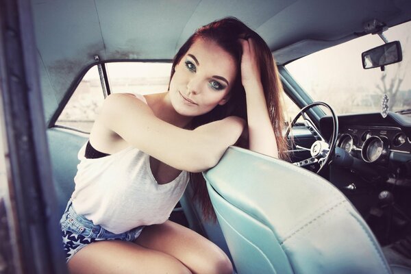 Brunette girl in a retro car