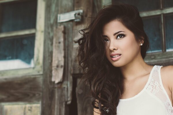 Hermosa chica morena en el fondo de una casa antigua