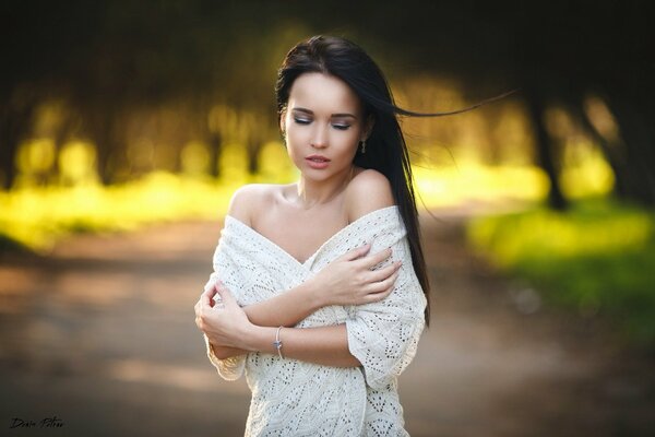 Foto di una bruna fragile in un maglione bianco