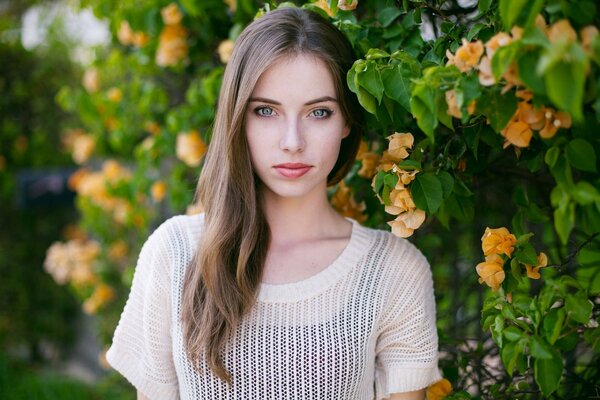 Fotoporträt des Modells megan coffey auf einem Hintergrund von Blumen