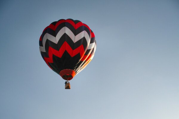 Palloncino rosso bianco e nero striscia sul cielo