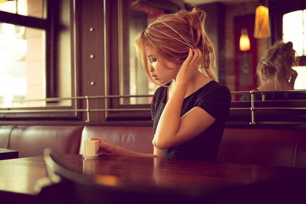 Mädchen im Café mit einer Tasse Kaffee