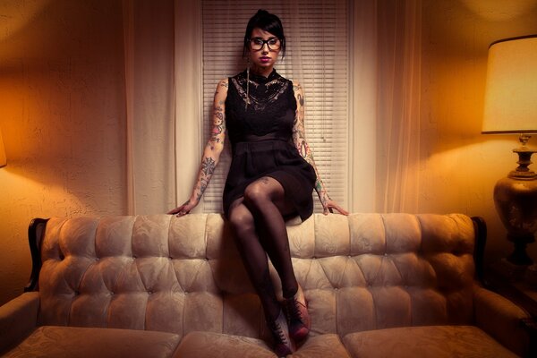 Girl with tattoos on the couch