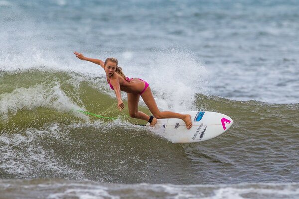 Das Mädchen auf dem Surfbrett kämpft mit den Wellen