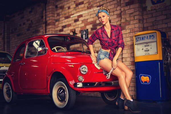 Chica en pantalones cortos con un pequeño coche rojo