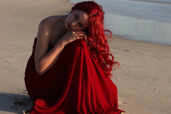 Ragazza con i capelli rossi infuocati sulla spiaggia