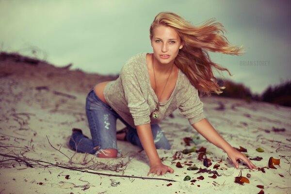 Chica en jeans fotografiado en la arena