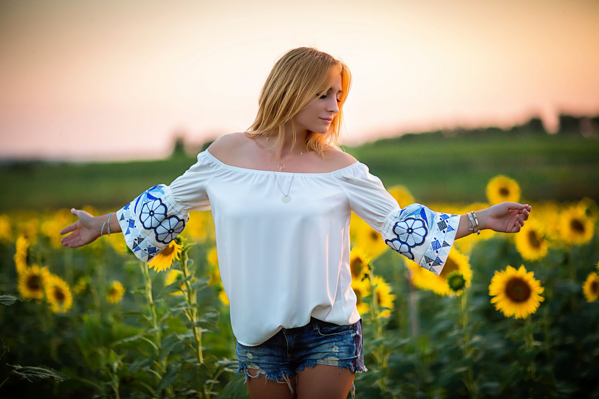 chica cara pelo pantalones cortos girasoles campo verano