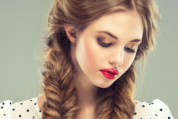 Chica con trenzas y lápiz labial rojo