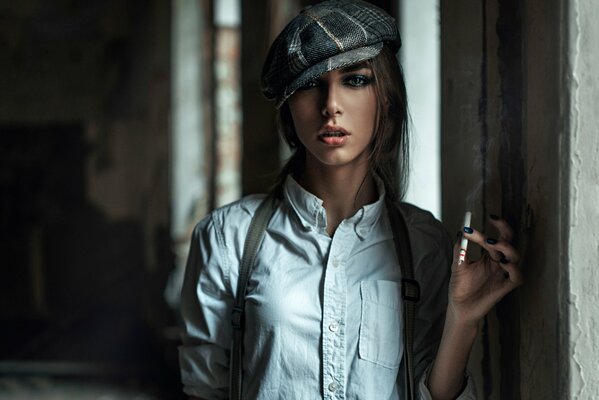 En el pasillo, una chica con una camisa blanca y una gorra