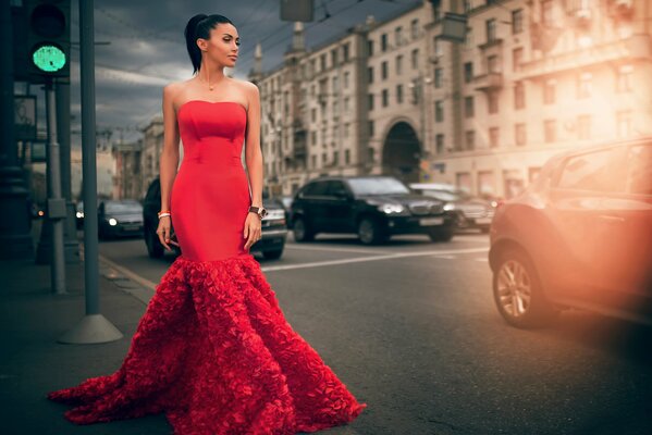 Spektakuläre Frau im roten Kleid auf der Straße