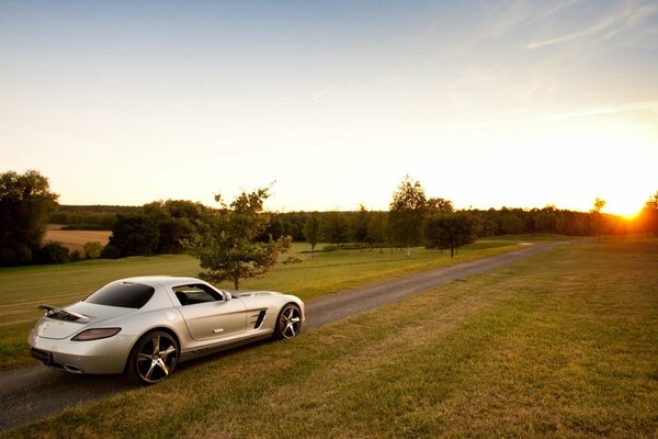 Hermoso coche en el fondo de la puesta de sol