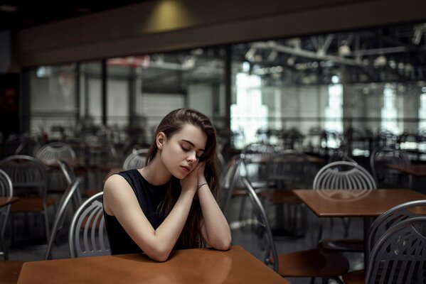 Chica tranquila en el café en la mesa