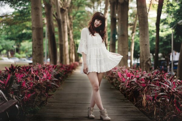 Asian woman in a white short dress on the road