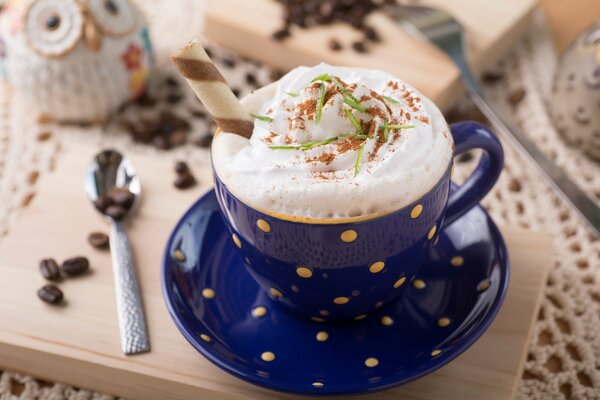 Cappuccino in blauer Tasse auf Holzbrett