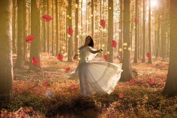 The lady of the fall of leaves whirling in a white dress among the foliage