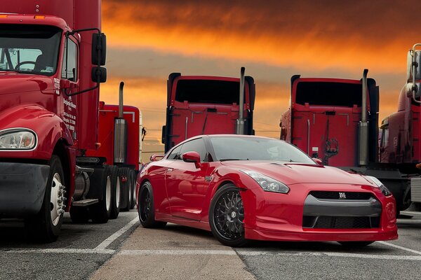 Voiture rouge dans un parking de camion