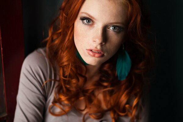 The look of a red-haired girl with curls and an earring