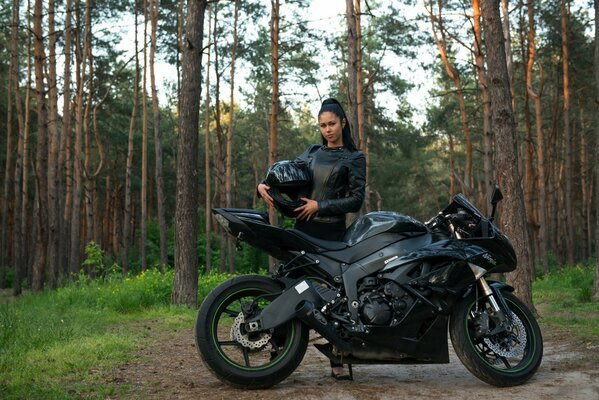 Brünette im Wald auf einem Sportbike