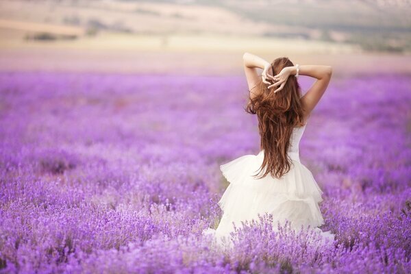 Una chica con un vestido blanco posa en un campo para un álbum familiar