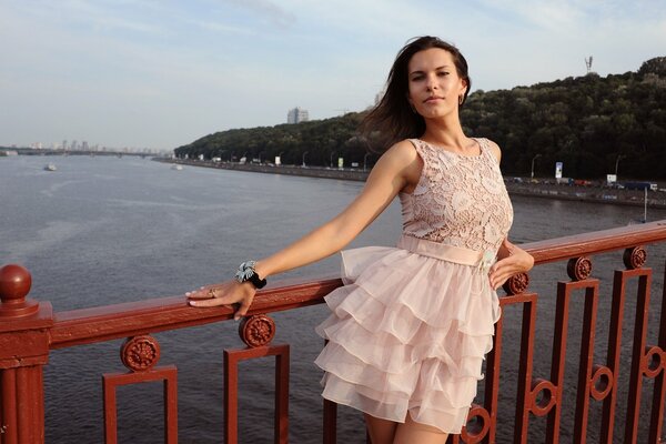 Ragazza in abito rosa in posa sul ponte