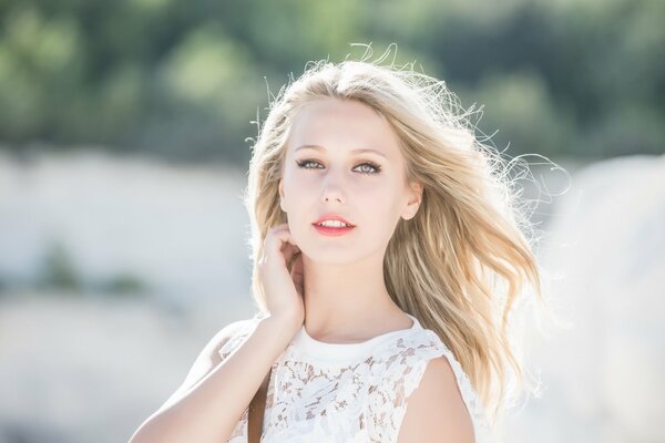 Rubia en un vestido blanco con el pelo revoloteando