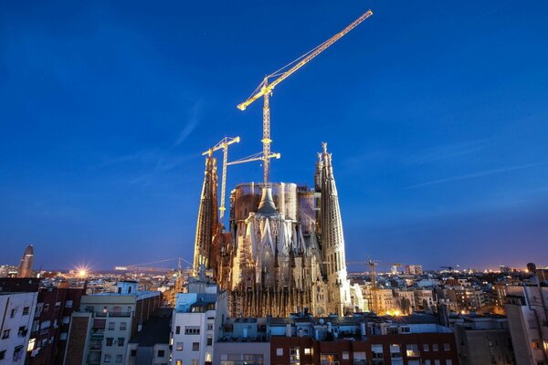 Città notturna di Barcellona con gru da costruzione illuminate