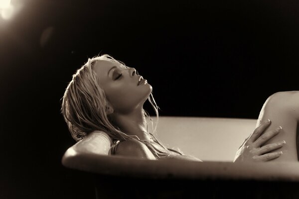 Beautiful girl in the bathtub on a black background