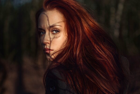 Fille Rousse avec une ombre sur le visage d une branche d arbre