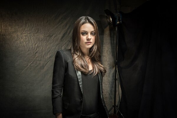 Actress Mila Kunis on a black background