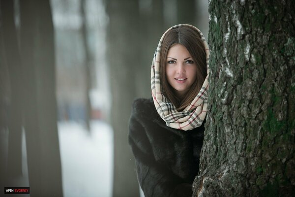 A girl near a tree with a scarf on her head