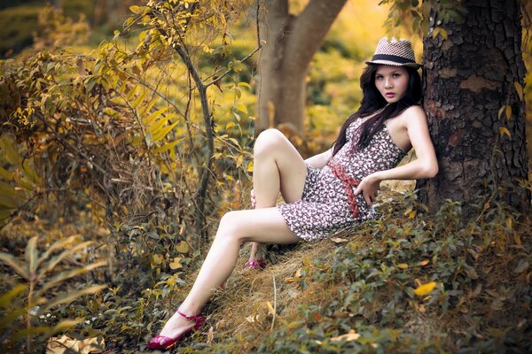 Fille dans un chapeau sous un arbre