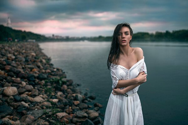 Mädchen friert am Abend am Teich ein