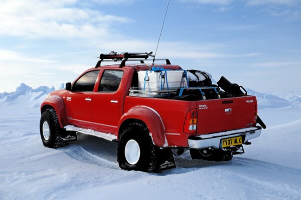 Toyota rojo en el Polo Norte en invierno en medio de la nieve