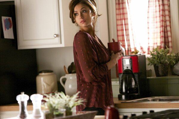 Nina Dobrev in the kitchen with a mug