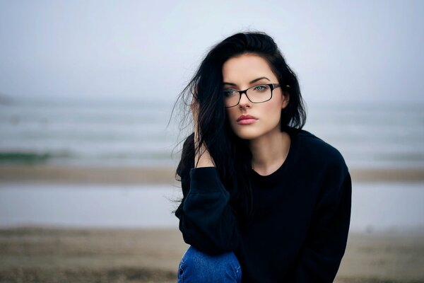 Fille à lunettes triste sur fond d eau