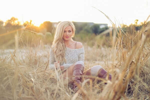 Chica con botas y suéter en el campo