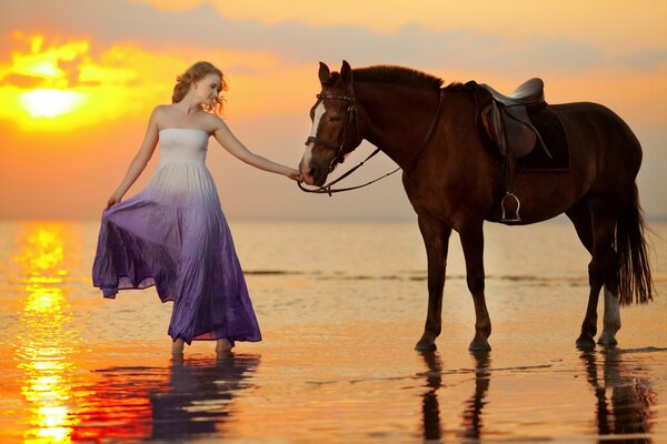 Fille avec un cheval sur la plage