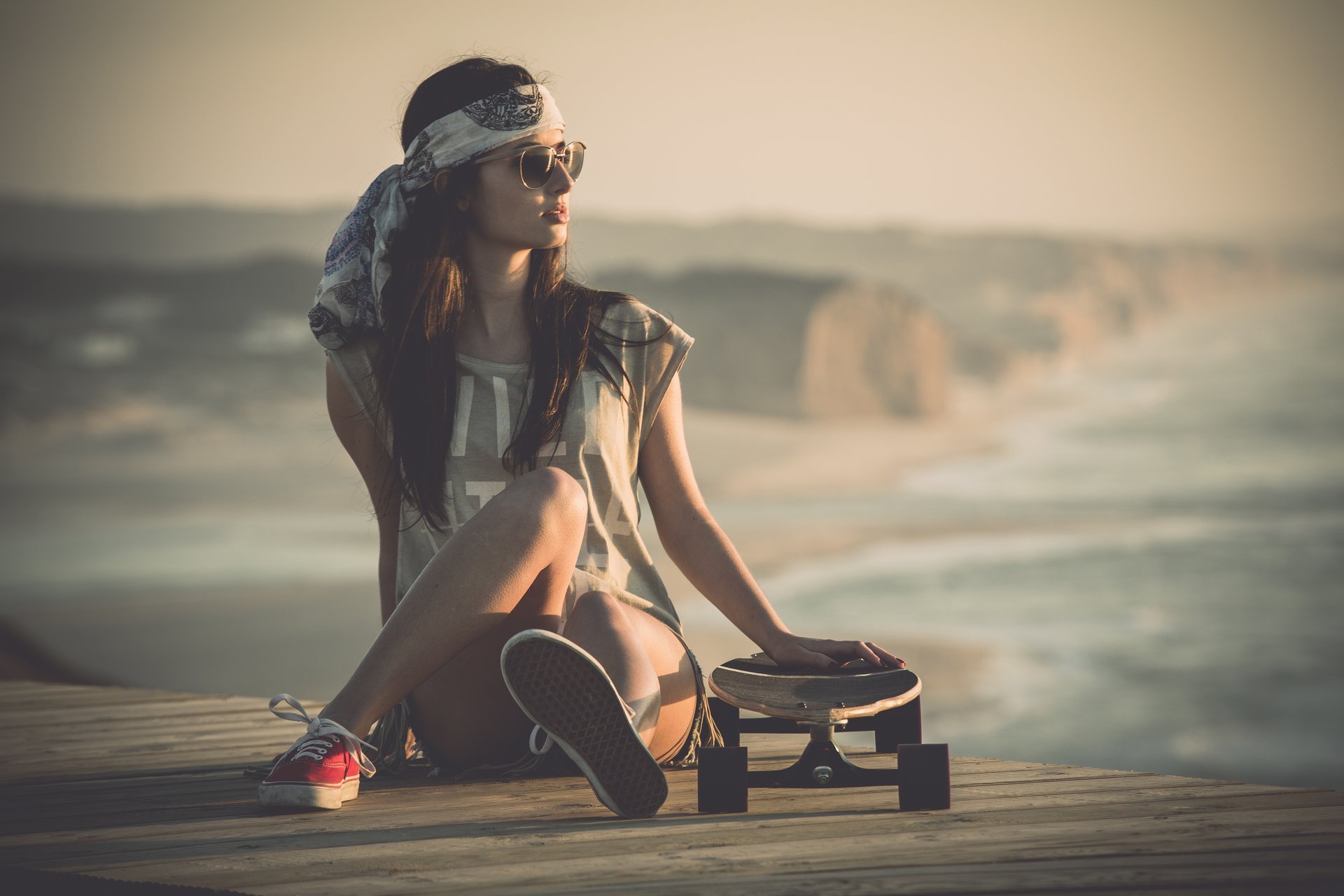 fille planche à roulettes assis jambes shorts baskets lunettes. regard