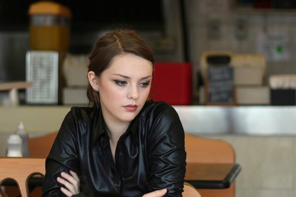 Ragazza con uno sguardo meditabondo in un caffè