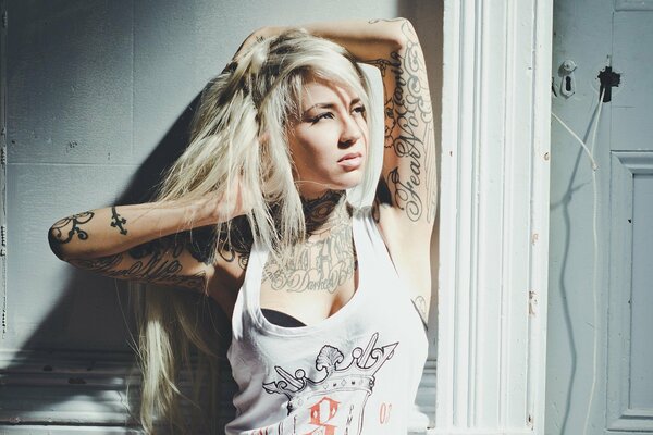 Blonde girl in a white T-shirt with a tattoo