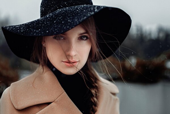 Portrait of Anna in a black hat with curly curls