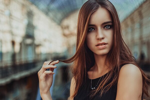 A girl with dark makeup on the background of the city