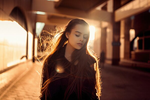 Fille aux cheveux longs dans les rayons du soleil