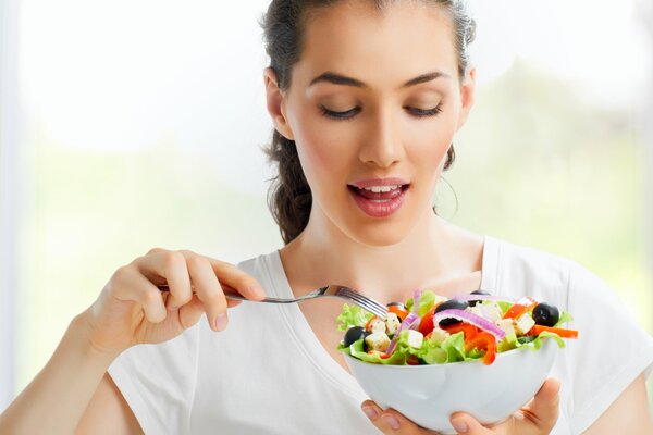 Ragazza che mangia insalata di verdure