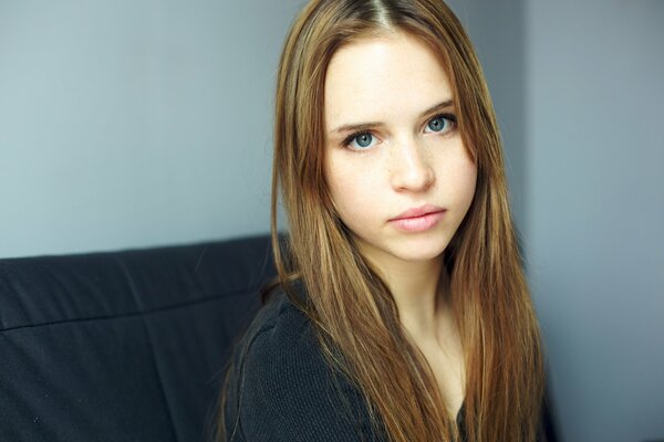 Fille aux yeux bleus regarde sérieusement la caméra