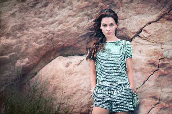 Brunette emilia clarke on a rock background