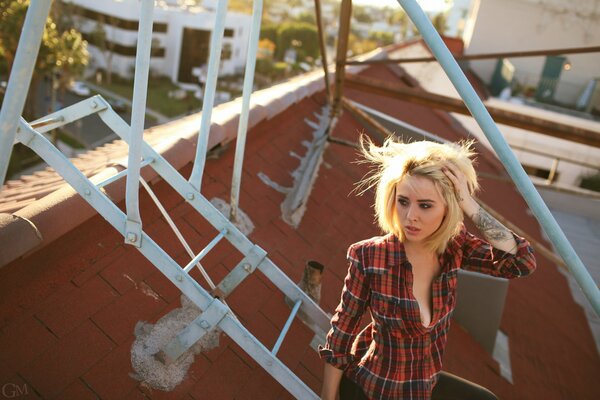 Blonde with tattoos and piercings on the roof